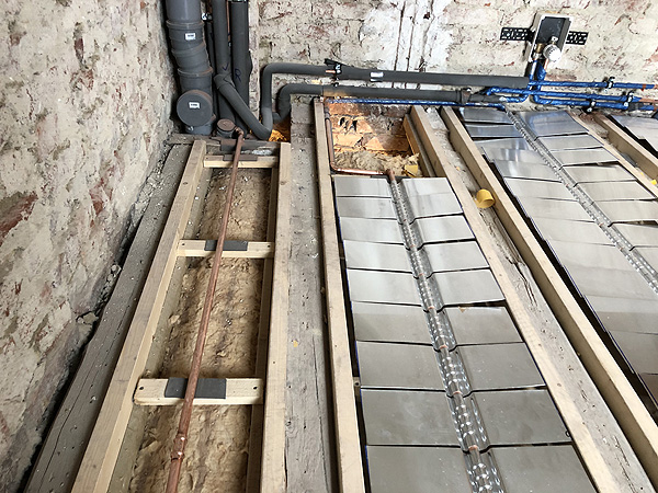 Badezimmer mit Holzbalkendecke und Janßen-Fussbodenheizung